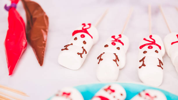 istock Making marshmallow snowman and reindeer on sticks hot chocolate toppers 1082486992