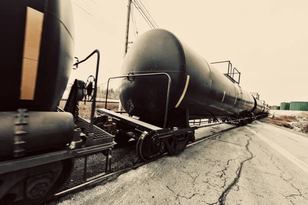 Chemical freight cars cross a road.