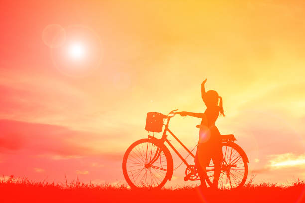 istock Silhouette Girl With Standing By Bicycle On Field During Sunset 1082491114