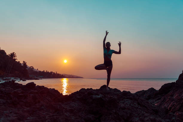 istock Woman practicing yoga on the beach 1082499440