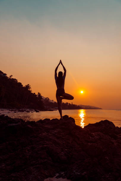 istock Woman practicing yoga on the beach 1082499444