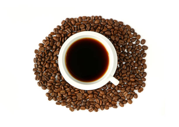 Black coffee in a white cup on the pile of roasted coffee beans isolated on white background