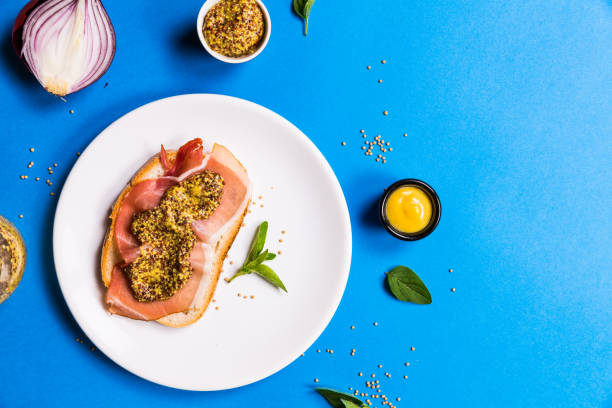 istock Sandwich with ham on a white ceramic plate, blue backgrounds 1082504046