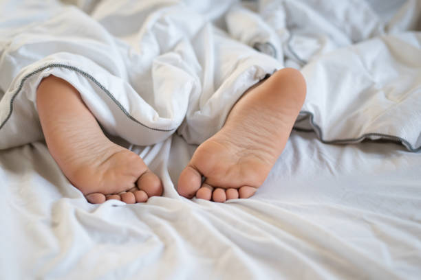 istock Low Section Of Boy Lying On Bed 1082506790