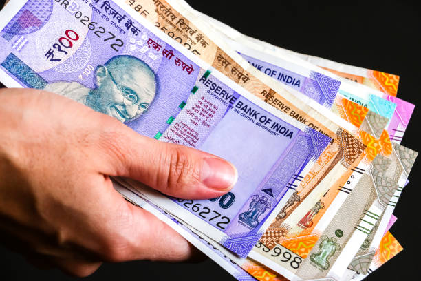 istock Woman's hands with new indian 50, 100, 200, 500, 2000 rupees banknotes. 1082517798