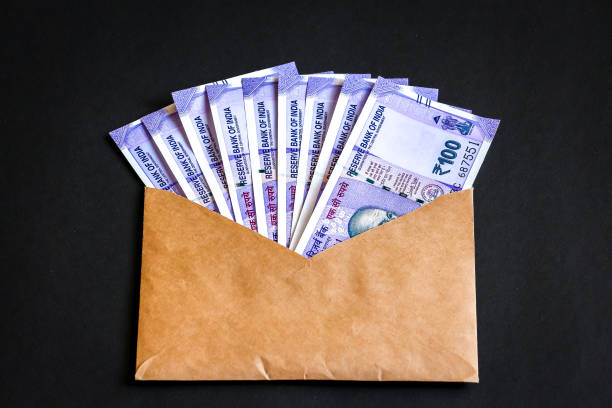 istock Envelope with brand new indian one hundred rupees banknotes. 1082523372