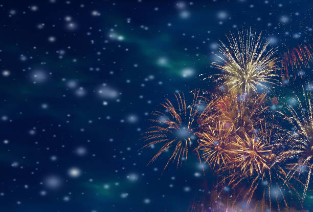 Colorful fireworks background with falling snow at night and with free space for text stock photo