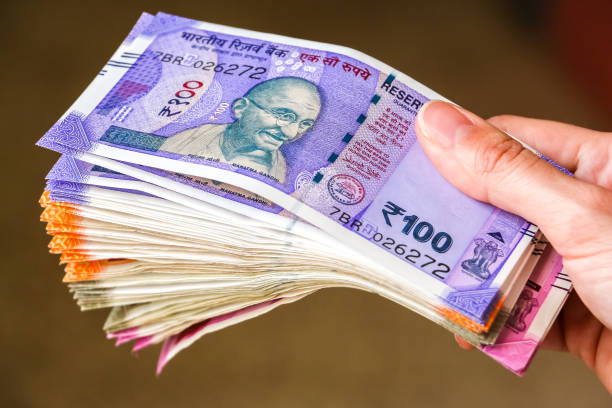 istock Woman's hands holding new indian 100, 200, 500, 2000 rupees banknotes. 1082528388