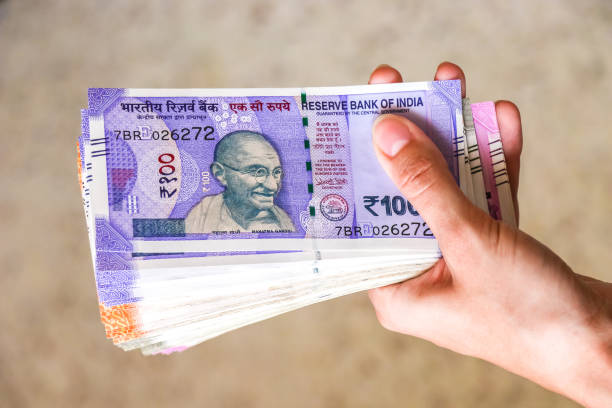 istock Woman's hands holding new indian 100, 200, 500, 2000 rupees banknotes. 1082528756