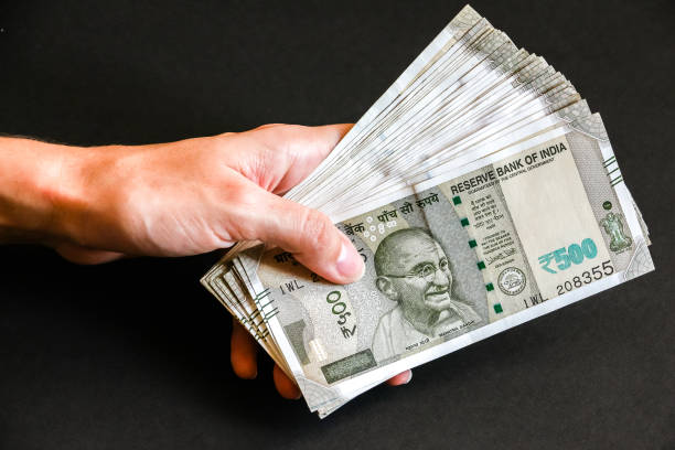 istock Woman's hands with new indian 500 rupees banknotes. 1082529436