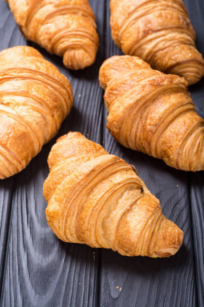 istock Croissants on wooden background 1082529998