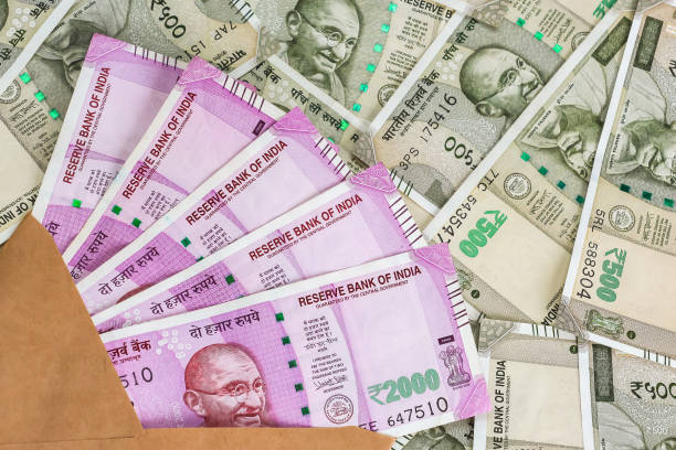 istock Envelope with brand new indian 2000 rupees banknotes. 500 rupee banknotes in background. 1082531910