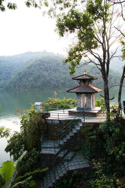 costa verde do lago fewa, pokhara. pequeno templo hindu e árvores floridas. - phew - fotografias e filmes do acervo