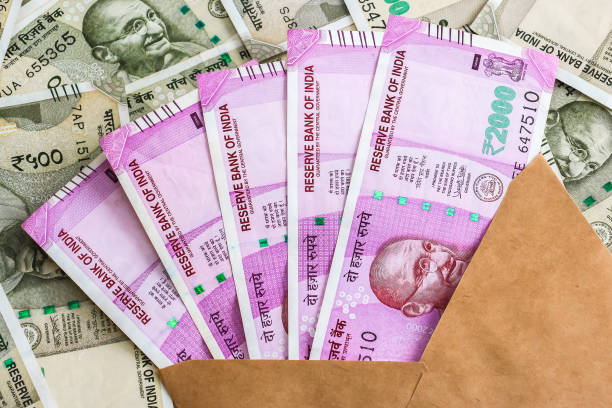 istock Envelope with brand new indian 2000 rupees banknotes. 500 rupee banknotes in background. 1082532112