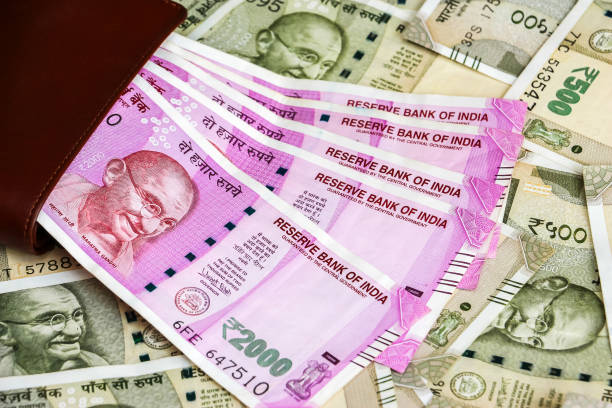 istock Leather wallet with brand new indian 2000 rupees banknotes. 500 rupee banknotes in background. 1082532120