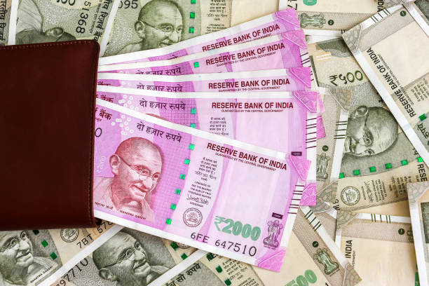 istock Leather wallet with brand new indian 2000 rupees banknotes. 500 rupee banknotes in background. 1082532410