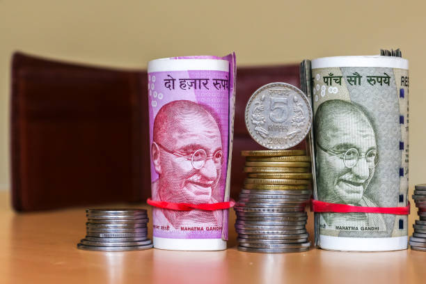 istock Indian rupees. Banknotes and stacked coins. Leather wallet in background. 1082536014