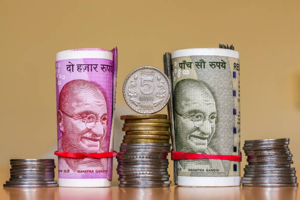 istock Indian rupees. Banknotes and stacked coins. 1082536236