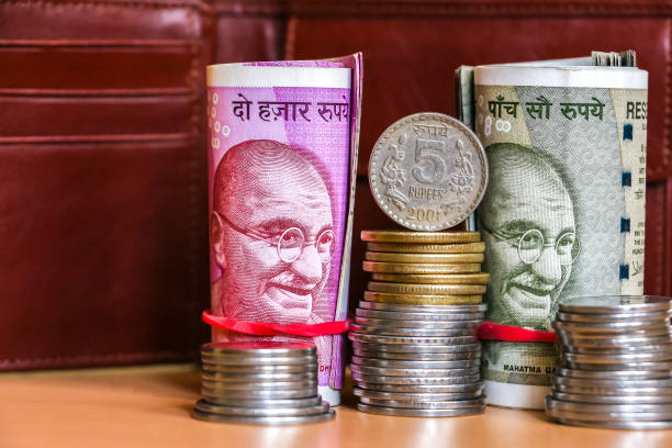 istock Indian rupees. Banknotes and stacked coins. Leather wallet in background. 1082537120
