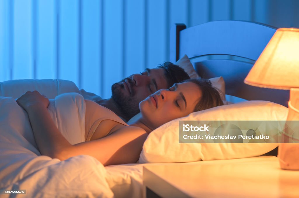 The couple sleeping in the bed. night time, full grip focus Sleeping Stock Photo