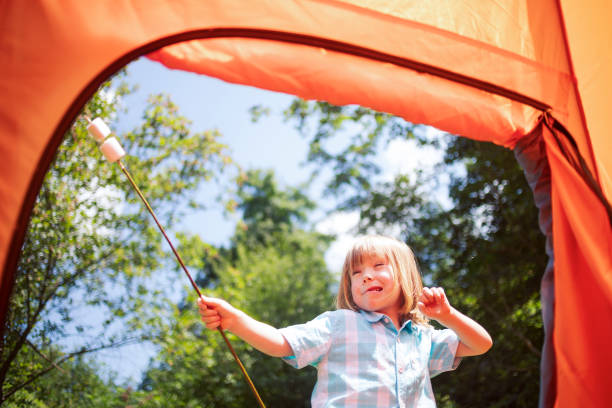 istock Playful child with marshmallow near tent 1082546820