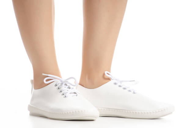 istock Female legs in white sneakers shoes beauty 1082548708