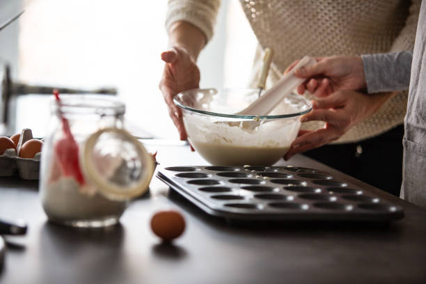 istock Mother and daughter making muffins in the kitchen 1082548886