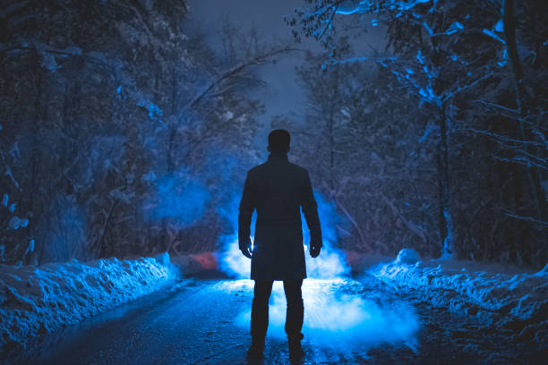 el hombre estar cerca del humo en el bosque de invierno. tarde noche - thick snow fotografías e imágenes de stock