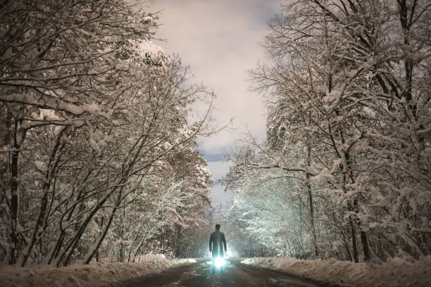 istock The man stand on the snowy road on the bright light background 1082549698
