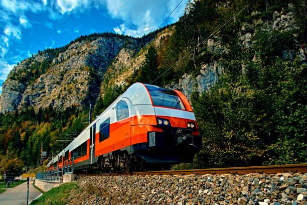 赤いブルートレインのオーストリアのアルプスの山々 の動きです。山の高速列車は、山でハルシュタット オーバートラウン鉄道駅に到着します。場所: リゾートの村ハルシュタット、ザルツ - mountain landscape rock european alps ストックフォトと画像