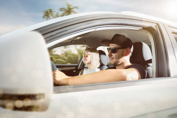 istock Young couple on summer vacation driving in a car 1082554614