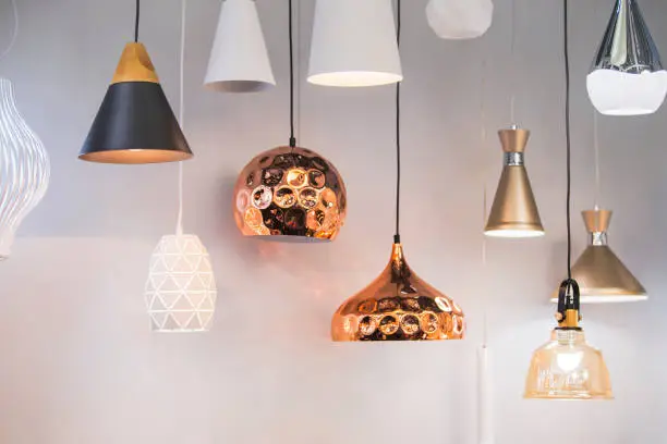 Photo of Different modern streamlined mirror copper chandeliers. Bubble metal copper shade pendant