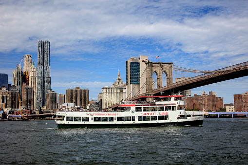 Circle Line Sightseeing Cruises is a harbor cruise company in Manhattan. The boat is just under the Brooklyn Bridge on east river in New York City.