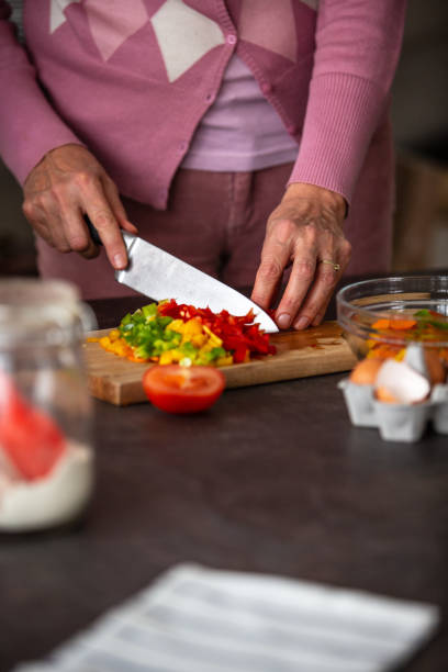 istock Senior woman cutting vegetables in the kitchen 1082562114
