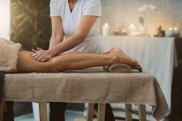 Spa massage Mid adult woman on anti cellulite massage in beauty salon human leg stock pictures, royalty-free photos & images