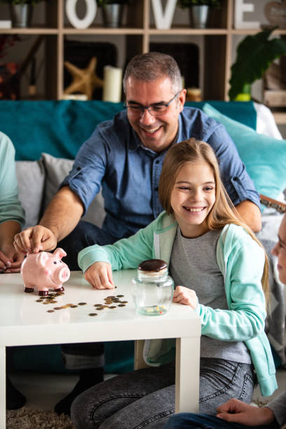 glückliche familie geld zu sparen - currency savings coin counting stock-fotos und bilder