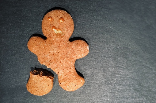 Gingerbread with broken leg on a dark background. Christmas cookies.
