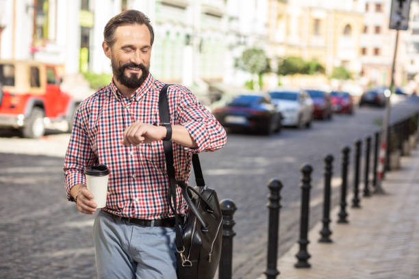 istock Positive smiling man checking time in the street 1082574798
