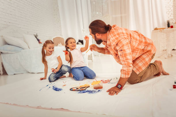 istock Delighted nice man holding a painting brush 1082577414