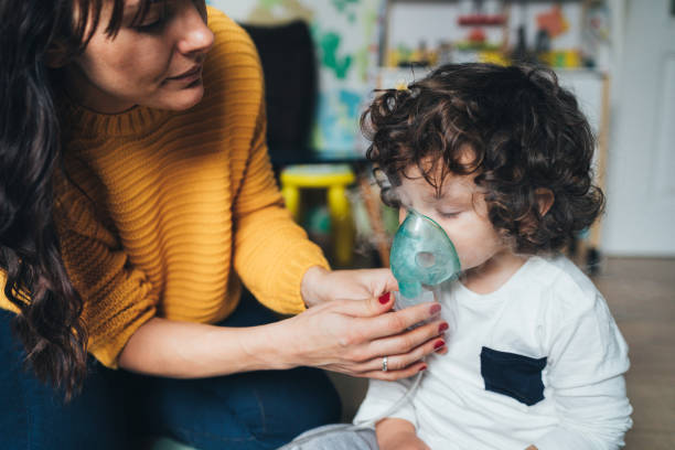 Little boy makes inhalation at home stock photo