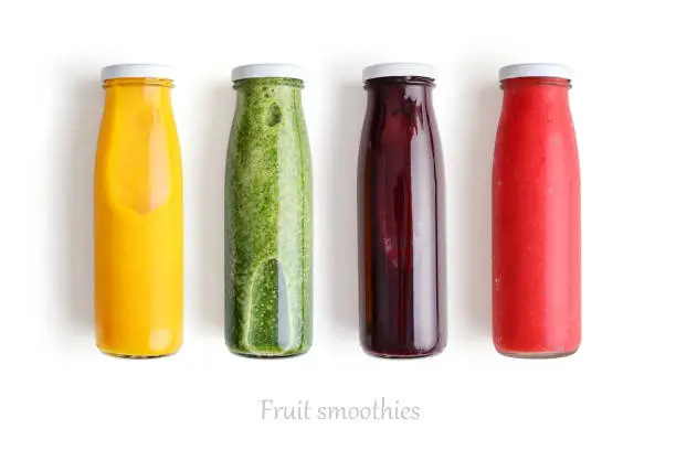 Colorful smoothies in glass bottles isolated on white background, top view.