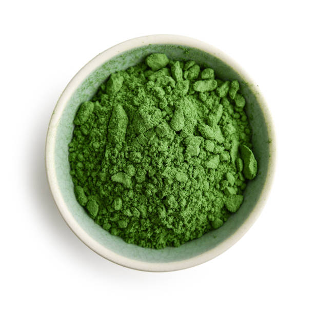 Bowl of spirulina powder Bowl of spirulina powder isolated on white background, top view spirulina stock pictures, royalty-free photos & images