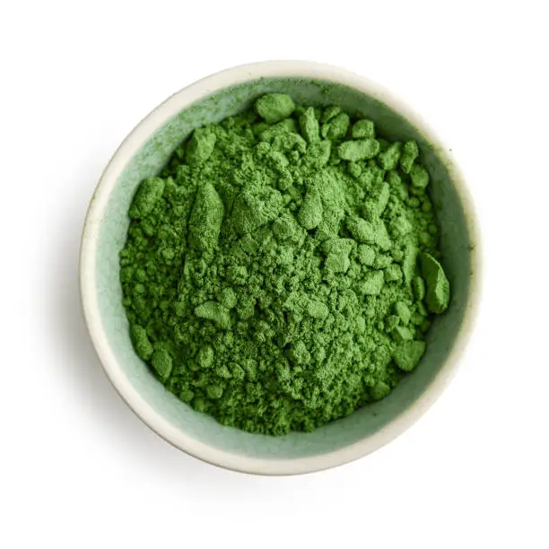 Bowl of spirulina powder isolated on white background, top view