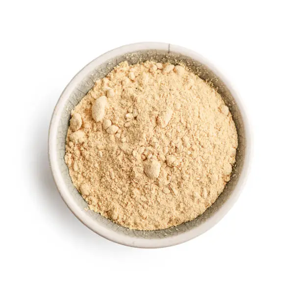 Bowl of maca powder isolated on white background, top view