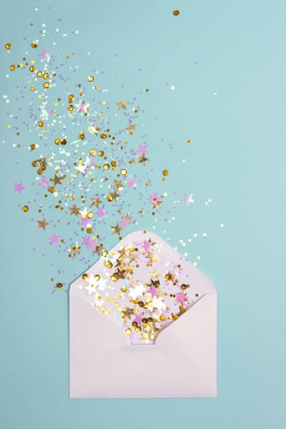 istock Golden and pink confetti scattered from envelope on pastel mint background. 1082606014