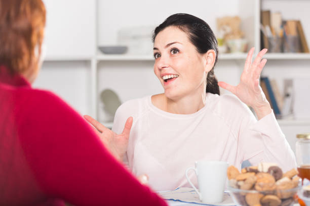 istock Happy young woman talking with mother at table 1082606152