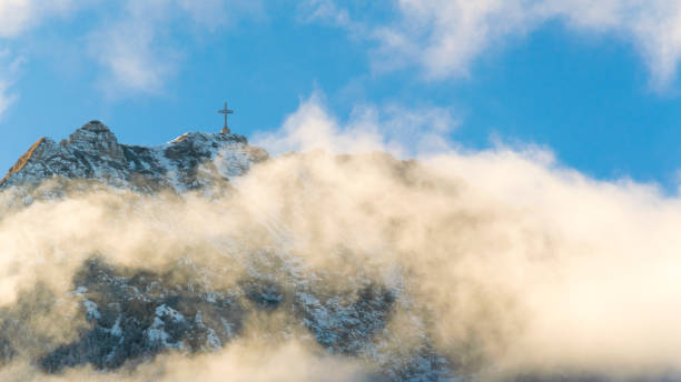 alpine landscape with peaks covered by snow and clouds