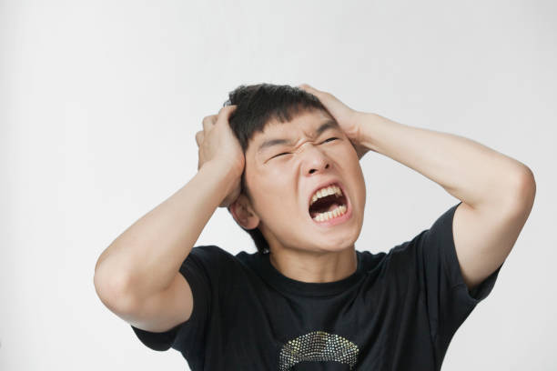 retrato de estúdio chinês homem gritando - confusion hand in hair tired touching - fotografias e filmes do acervo