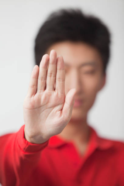 chinesischer mann blockierende geste - disappointment hand sign gesturing young adult stock-fotos und bilder