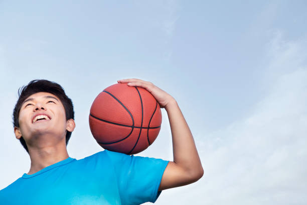 istock Chinese man holding basketball 1082651900
